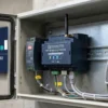 IoTize Parking Guidance Gateway IoT edge controller mounted on a DIN rail inside a roadside parking field cabinet