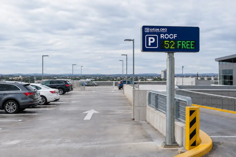IoTize.ORG smart parking sign on a rooftop parking deck showing 52 free spaces in the ROCF section