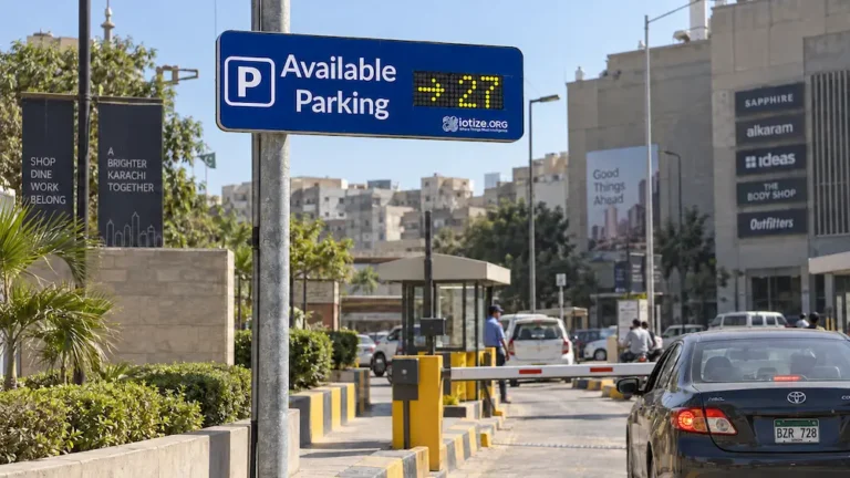 IoTize flip-dot parking guidance sign showing available spaces at a Karachi parking entrance.